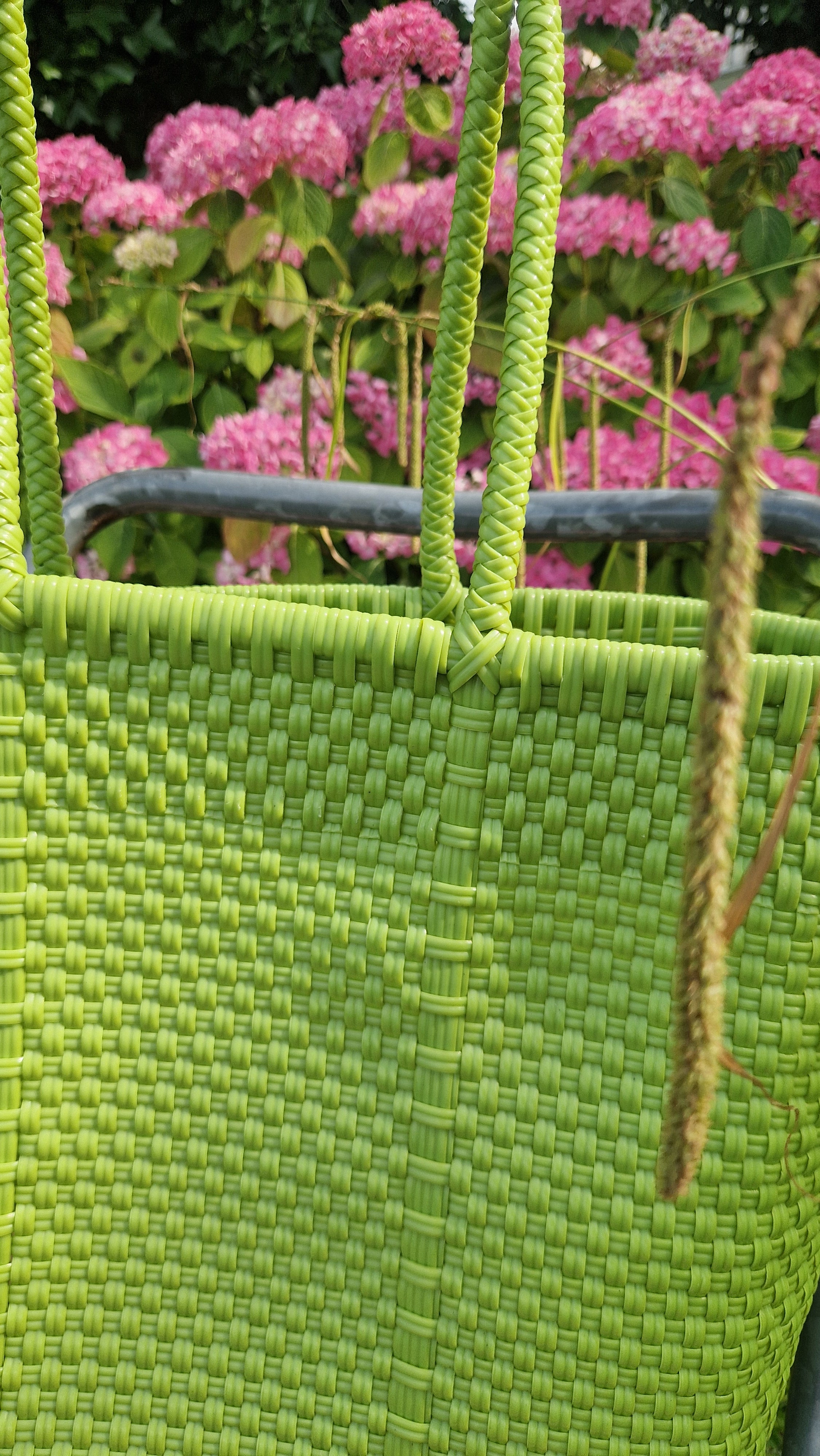 Alma Tote Chica in Grün — handgeflochtene Tragetasche aus recyceltem Kunststoff, kompakte Grösse mit langen Henkeln