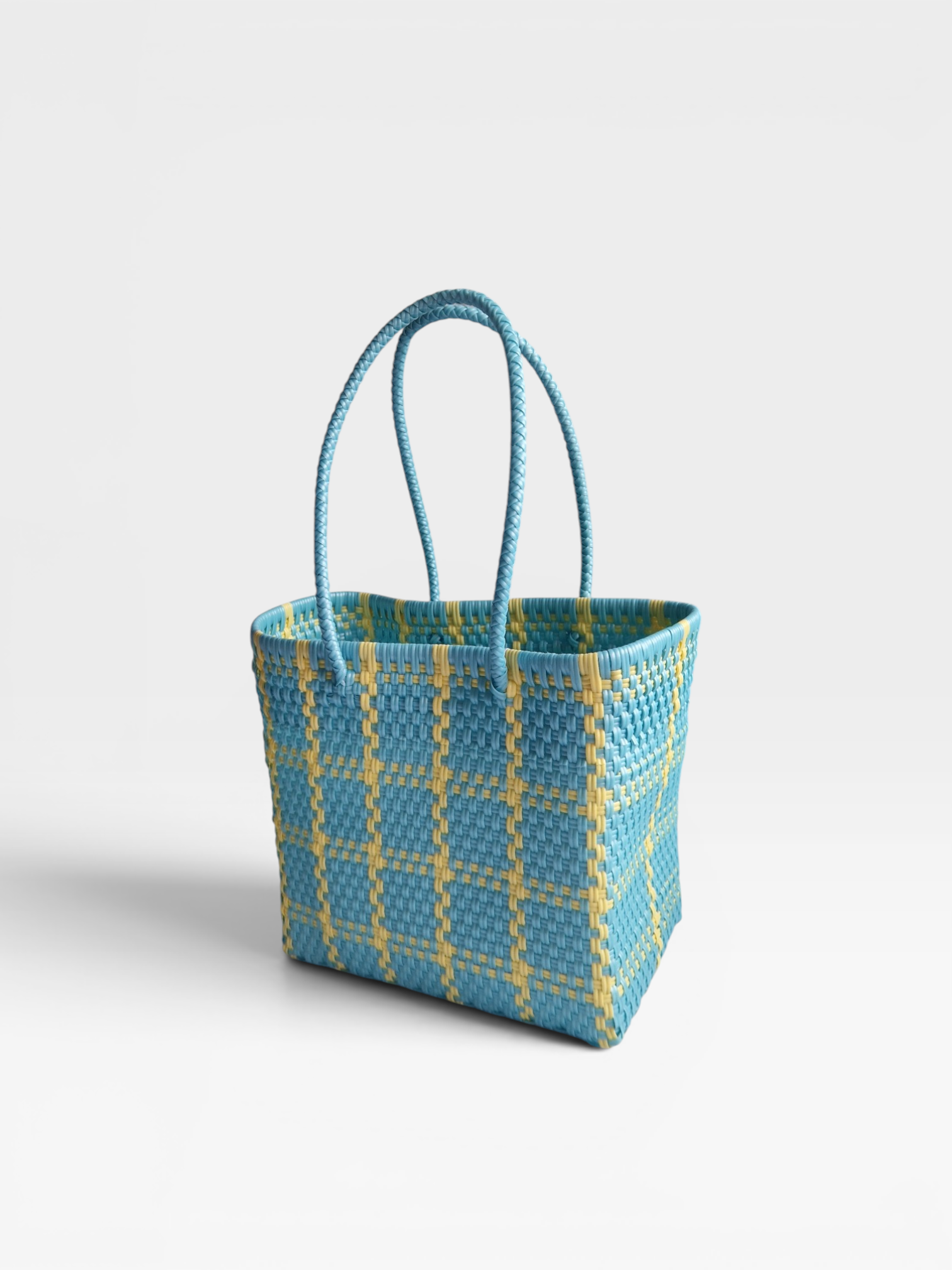 Alma Tote Chica in Hellblau kariert — handgeflochtene Tragetasche aus recyceltem Kunststoff, kompakte Grösse mit langen Henkeln
