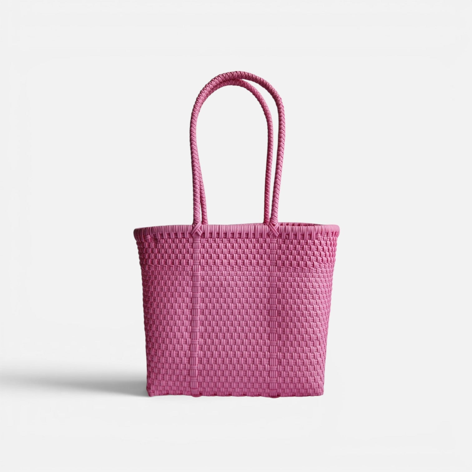 Alma Tote Chica in Pink — handgeflochtene Tragetasche aus recyceltem Kunststoff, kompakte Grösse mit langen Henkeln