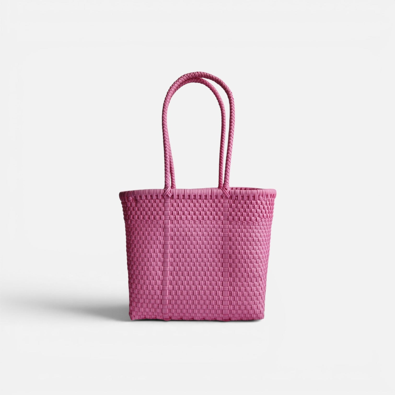 Alma Tote Chica in Pink — handgeflochtene Tragetasche aus recyceltem Kunststoff, kompakte Grösse mit langen Henkeln