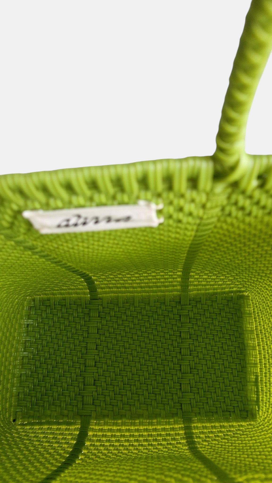 Alma Tote Chica in Grün — handgeflochtene Tragetasche aus recyceltem Kunststoff, kompakte Grösse mit langen Henkeln
