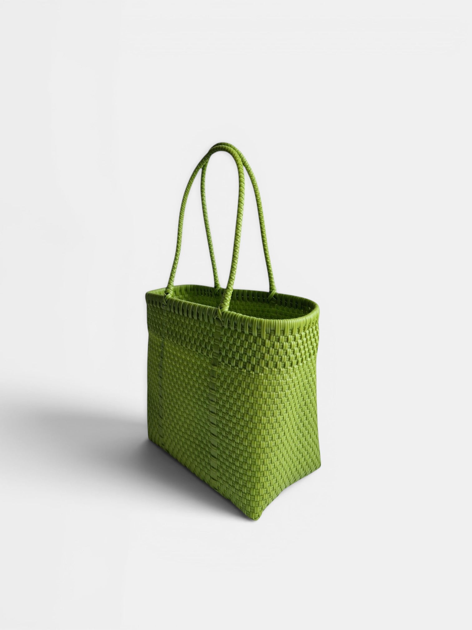 Alma Tote Chica in Grün — handgeflochtene Tragetasche aus recyceltem Kunststoff, kompakte Grösse mit langen Henkeln