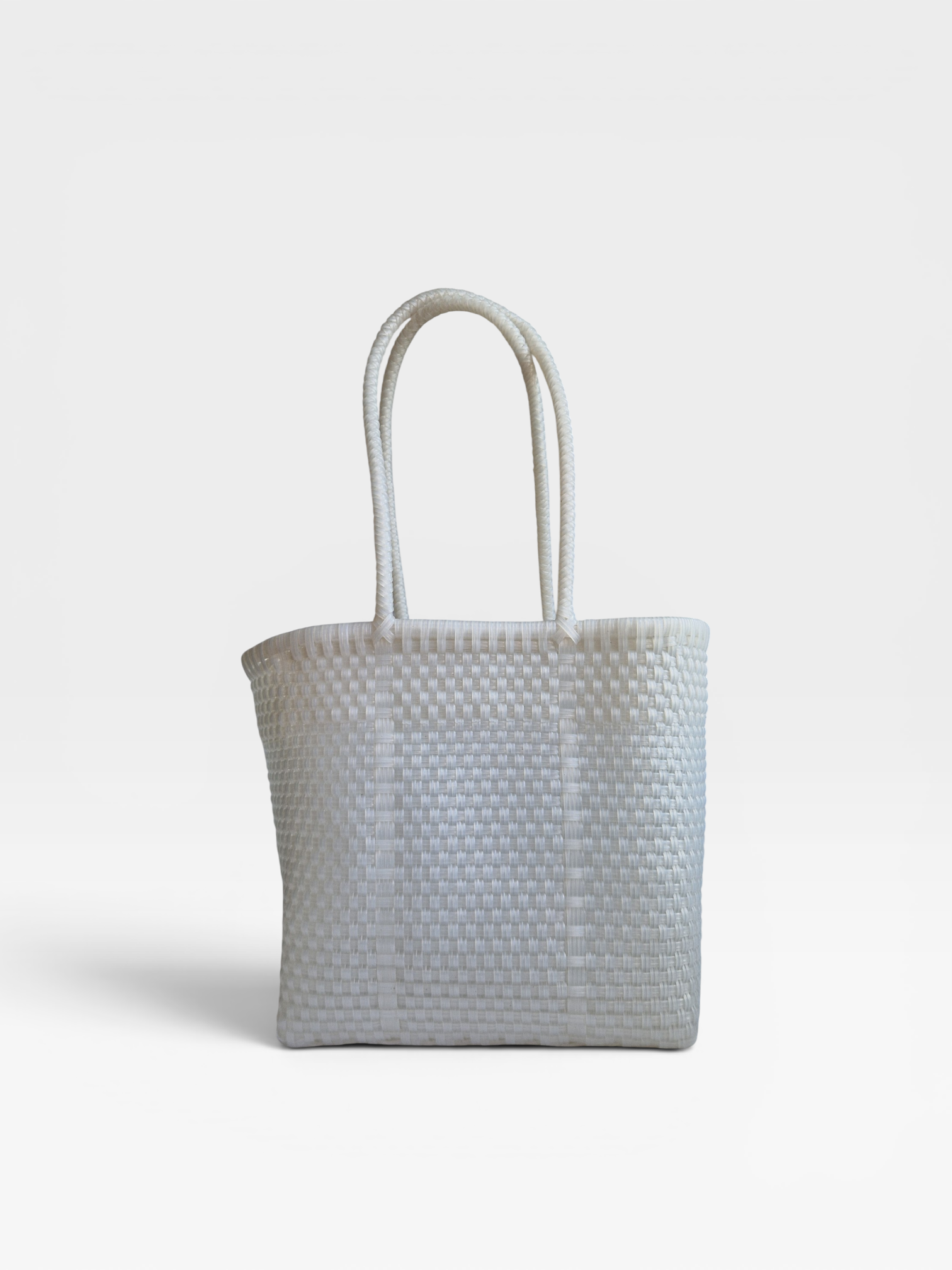 Alma Tote Chica in Clear — handgeflochtene Tragetasche aus recyceltem Kunststoff, kompakte Grösse mit langen Henkeln