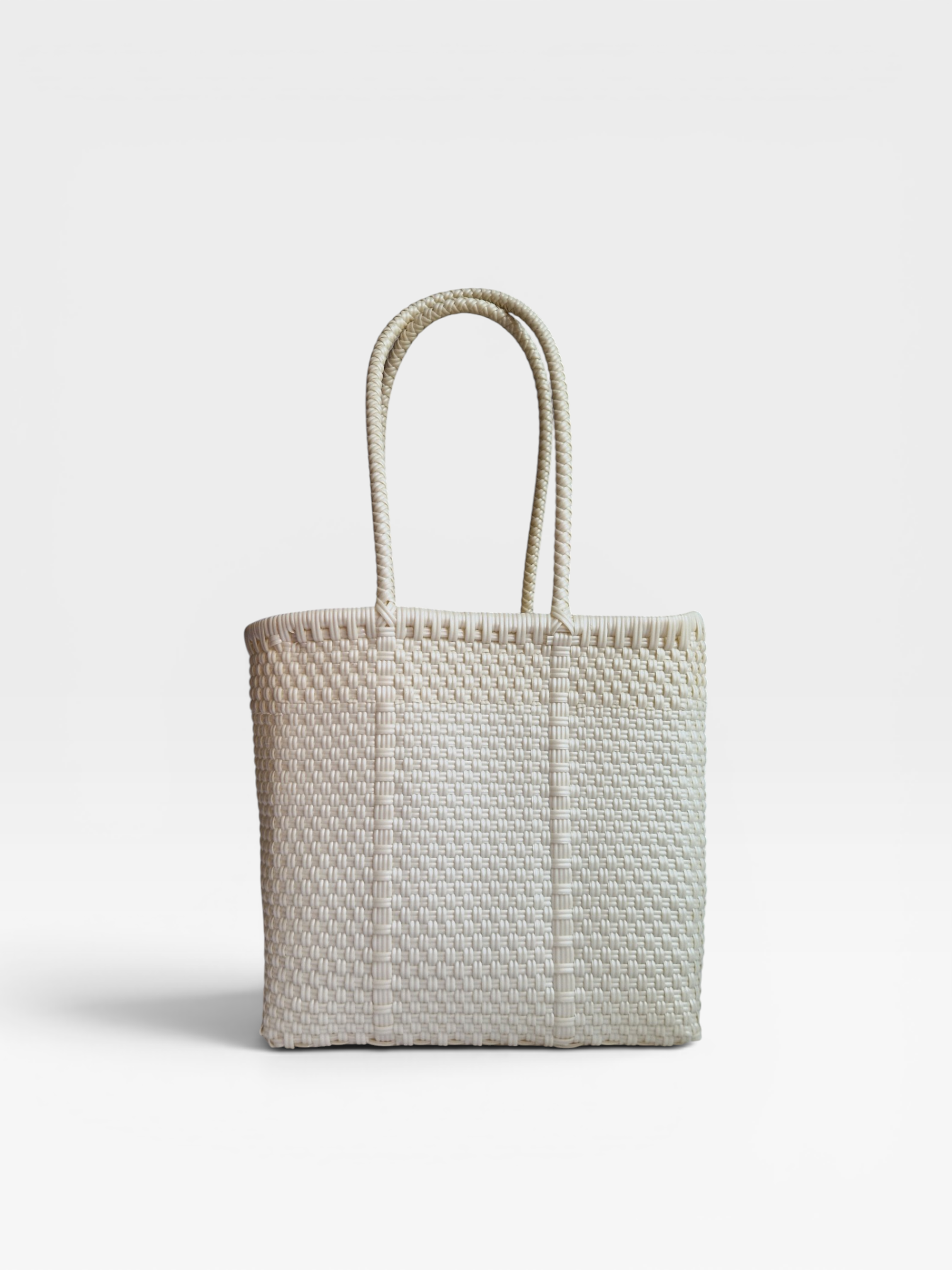 Alma Tote Chica in Weiss— handgeflochtene Tragetasche aus recyceltem Kunststoff, kompakte Grösse mit langen Henkeln