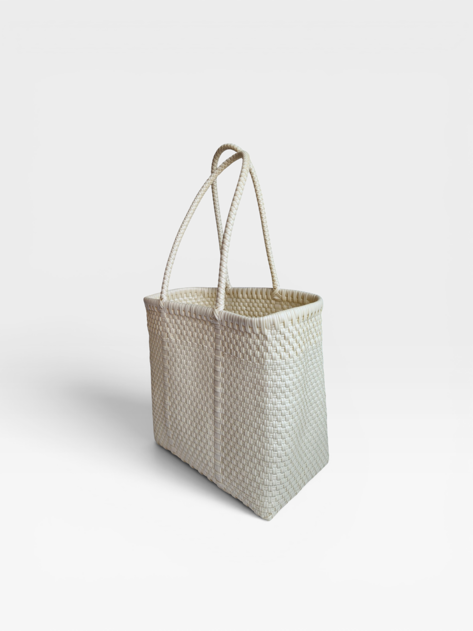 Alma Tote Chica in Weiss— handgeflochtene Tragetasche aus recyceltem Kunststoff, kompakte Grösse mit langen Henkeln